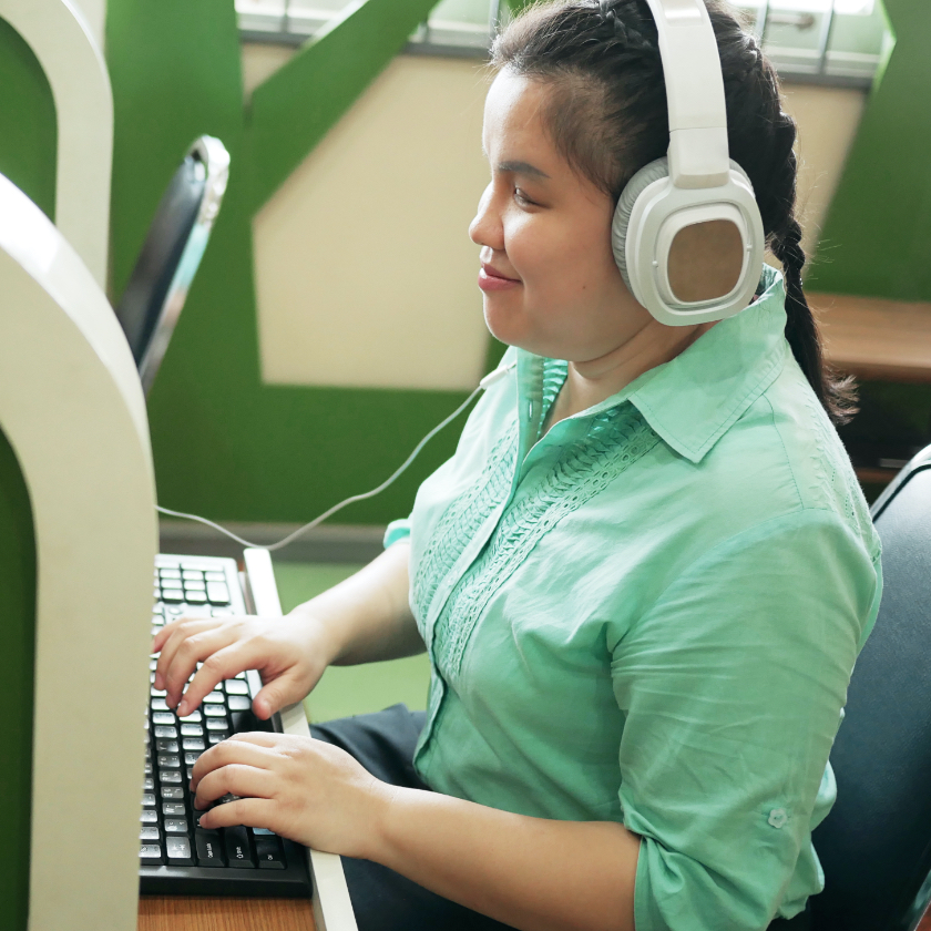 woman wearing headphones while on computer